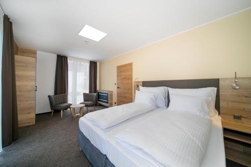 a bedroom with a large white bed and a desk at Hotel Zelený potok in Pec pod Sněžkou