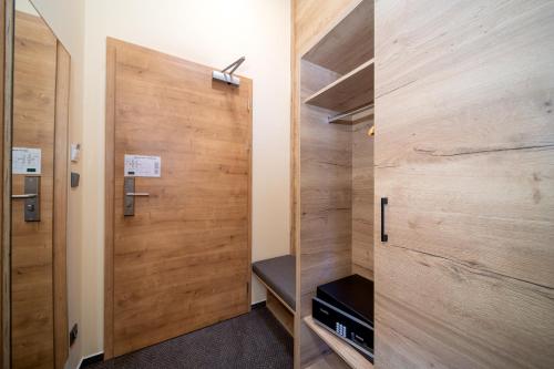 a room with a wooden closet with a door at Hotel Zelený potok in Pec pod Sněžkou