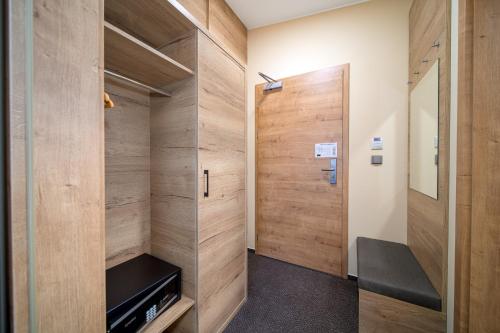 a walk in closet with wood paneling and a door at Hotel Zelený potok in Pec pod Sněžkou