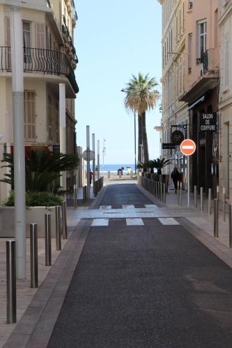 an empty street with buildings and a palm tree at Cannes CROISETTE, Palais des Festivals, Beaches, Apart Residence Le MINERVE in Cannes
