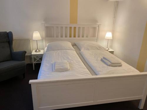a white bed with two pillows on top of it at Pension Villa Ostseetraum in Warnemünde