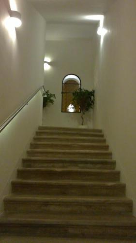 a hallway with stairs with a window and a plant at Dimora di Charme Cassaro 168 in Marsala