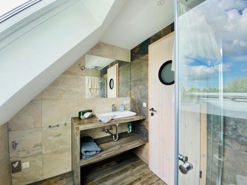 La salle de bains est pourvue d'un lavabo et d'une douche. dans l'établissement Ferienwohnung im Bootshaus, à Putbus