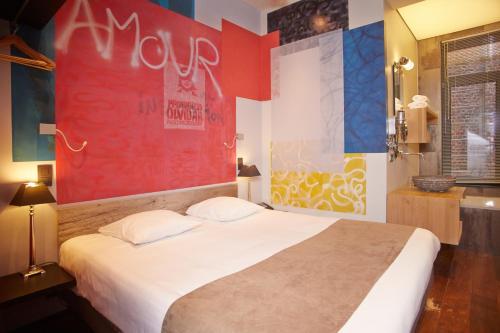a bedroom with a large bed with a red wall at Boutique Hotel Saint-Géry in Brussels