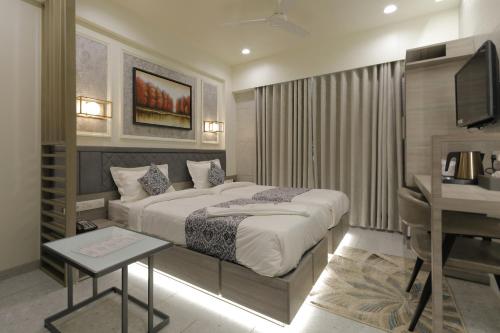 A bed or beds in a room at Hotel Elysian Residency