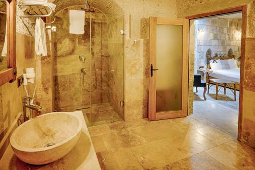 a bathroom with a tub and a shower and a sink at Design Cave Hotel in Goreme