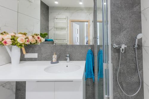 uma casa de banho com um lavatório e um chuveiro em HollyŁódź Apartment NETFLIX em Lódź
