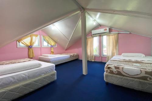um quarto com três camas numa tenda em OYO HOME 90285 Pogimpaan Homestay em Ranau