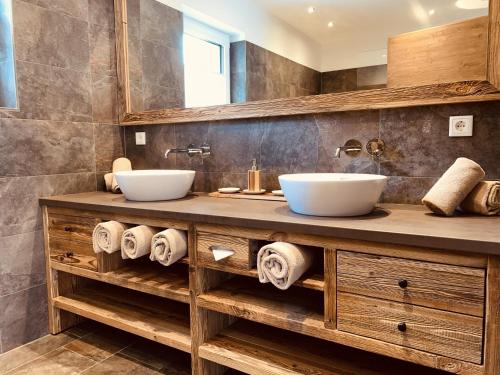 a bathroom with two sinks on a wooden vanity at Die Tauplitz Lodges - Penthouse Grimming D7-1 by AA Holiday Homes in Tauplitz
