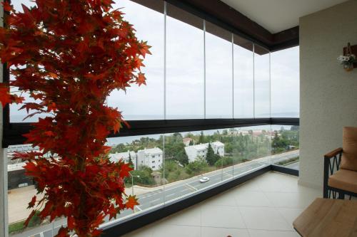 a room with a large window with red leaves at Armoni Deluxe Suites Trabzon in Trabzon