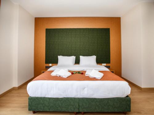 a bedroom with a large bed with two towels on it at Armoni Deluxe Suites Trabzon in Trabzon