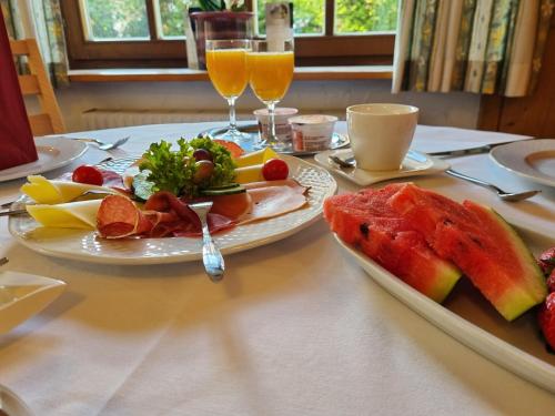 uma mesa com dois pratos de comida e bebidas em Hotel Pension Geiger em Bad Tölz