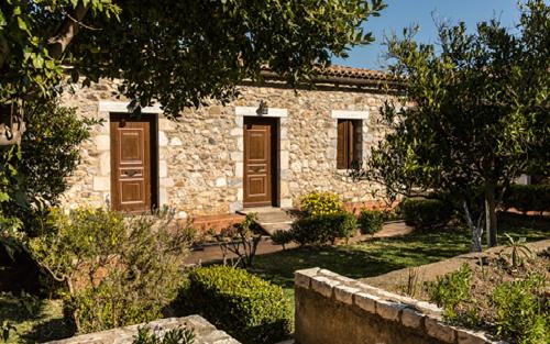 a stone house with brown doors in a yard at Pyrgos Of Mystra in Mystras