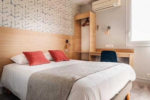 1 dormitorio con 1 cama blanca grande con almohadas rojas en Contact Hôtel Astréa Nevers Nord et son restaurant la Nouvelle Table, en Varennes Vauzelles