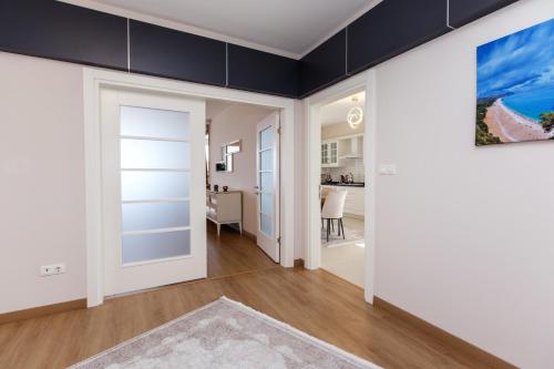a living room with white walls and a sliding door at Armoni Deluxe Suites Trabzon in Trabzon