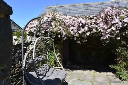 a bench with pink flowers on it next to a building at Crug Glas Country House in St. Davids
