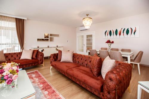 Armoni Deluxe Suites Trabzon في طرابزون: غرفة معيشة مع أريكة حمراء وطاولة