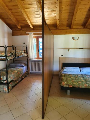 a bedroom with two bunk beds and a wooden ceiling at Bungalows in Camping Solarium in Domaso