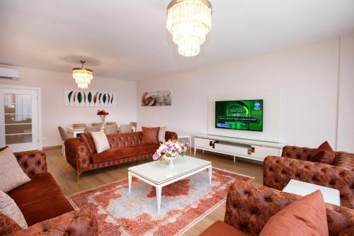 a living room with couches and a tv at Armoni Deluxe Suites Trabzon in Trabzon