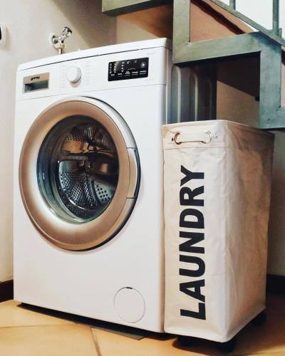 a washing machine with a paper bag next to it at Vittoria Holiday House Stresa in Stresa