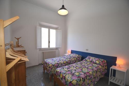 a bedroom with two beds and a window at PRIMAVERA TRILO - Zona mare con spazio esterno, clima e posto auto in Marina di Campo