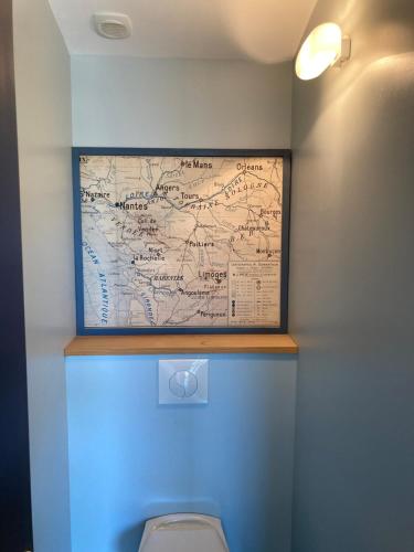 a map on the wall above a toilet in a bathroom at Maison contemporaine Oléron in Saint-Denis-dʼOléron