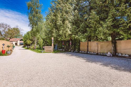 a gravel driveway with a fence and trees at Gîtes Sérénaé avec vue sur rivière in Val de Vesle
