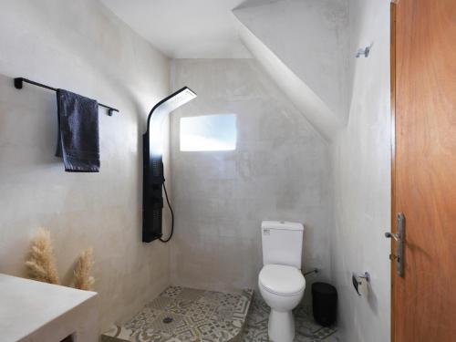 a bathroom with a toilet and a phone on the wall at Secret Gem Suites in Oia