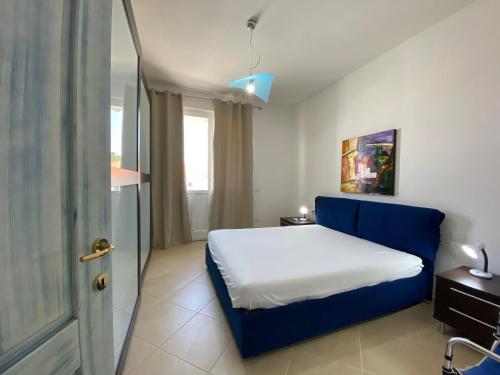 a bedroom with a blue bed and a window at Sabrina Apartments in Porto Pino