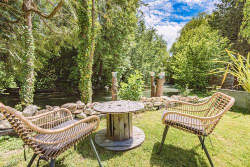 a table and two chairs and a table in a yard at Gîtes Sérénaé avec vue sur rivière in Val de Vesle