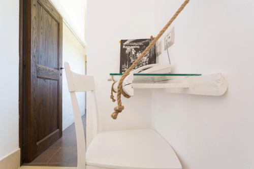 Cette chambre comprend des toilettes blanches et une balançoire. dans l'établissement Antico Convento Dei Cappuccini, à Raguse