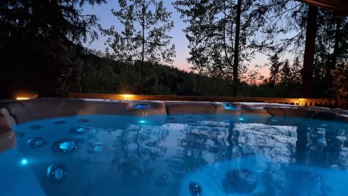 una bañera de hidromasaje en un patio trasero por la noche en Villa Lumi 10 henkilölle, Himos Länsihuippu en Jämsä
