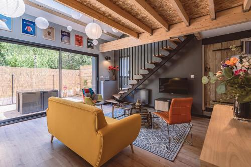 a living room with yellow chairs and a staircase at Gîtes Sérénaé avec vue sur rivière in Val de Vesle