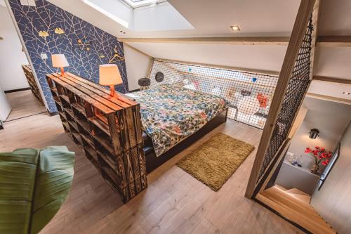 a attic bedroom with a bed and a mirror at Gîtes Sérénaé avec vue sur rivière in Val de Vesle
