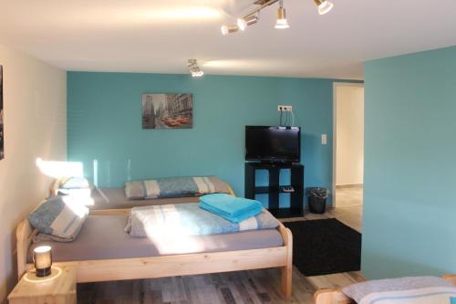 a bedroom with two beds and a tv in it at Gästehaus Silvia in Freigericht