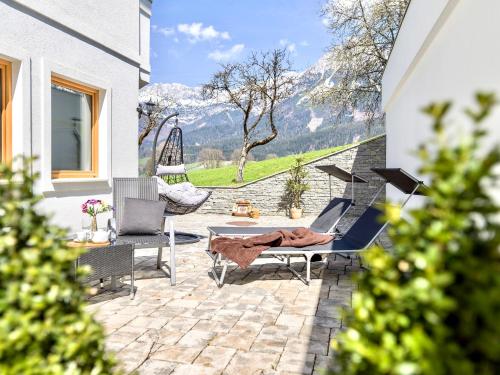 a person laying in a hammock on a patio with a view at Appartementhaus Tanja in Ellmau