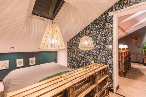 a bedroom with a bed and a wall with flowers at Gîtes Sérénaé avec vue sur rivière in Val de Vesle