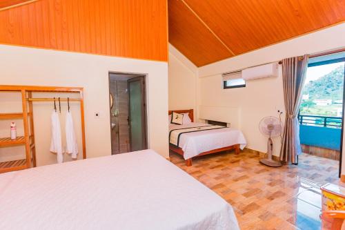 a bedroom with two beds and a balcony at Phong Nha Green Homestay in Phong Nha