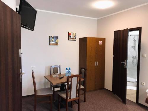 a room with a table and chairs and a television at Astral in Raszyn