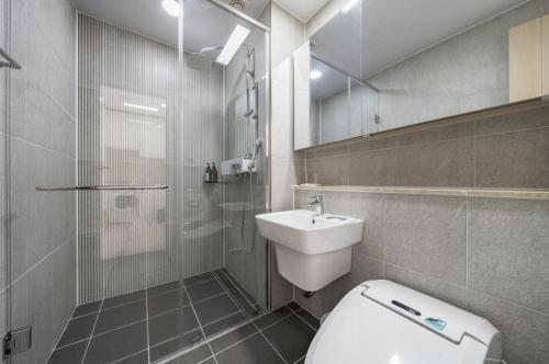 a bathroom with a toilet and a shower and a sink at The Mark Sokcho Residence hotel in Sokcho