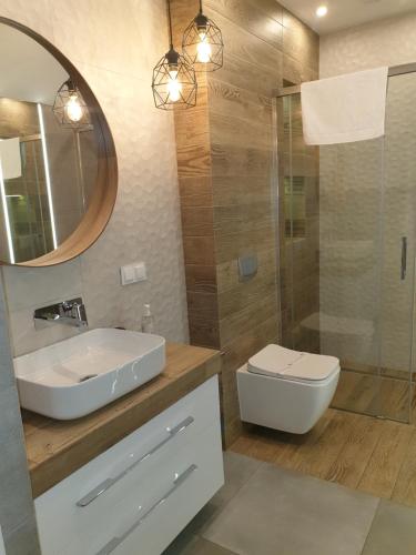 y baño con lavabo, aseo y espejo. en Apartament Triventi Karpacz, en Karpacz