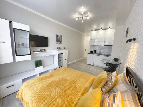 a bedroom with a large bed and a kitchen at Apartment Studio New York 45 in Irpin'