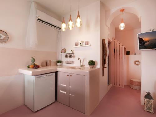 a kitchen with white cabinets and a sink at Secret Gem Suites in Oia