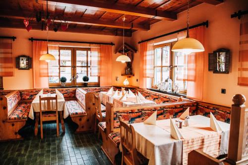 un restaurant avec des tables, des chaises et des fenêtres dans l'établissement Gasthof Oberer Wirt, à Elisabethszell