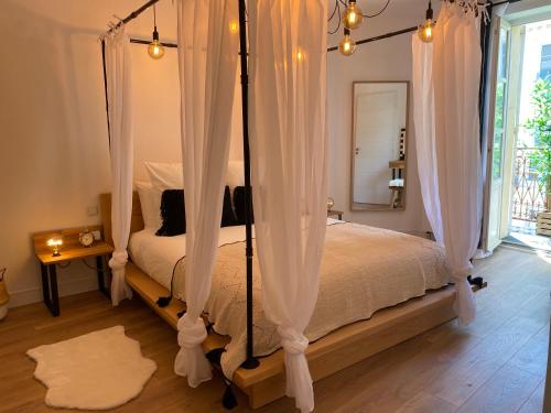 a bedroom with a canopy bed with white curtains at My Pad Provence 7 in Avignon