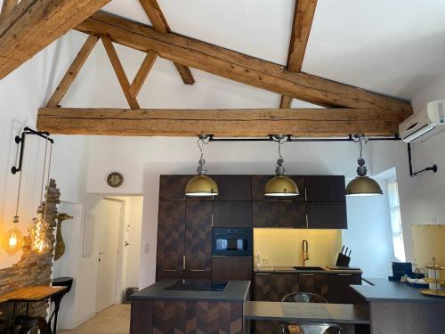 a kitchen with wooden ceilings and wooden beams at My Pad Provence 7 in Avignon