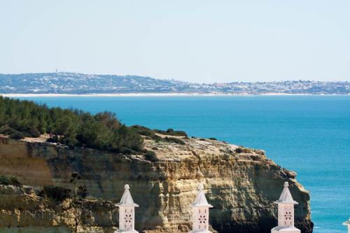 two white towers on a cliff near the ocean at Casa Sol - Vista Mar - Praia Benagil in Lagoa