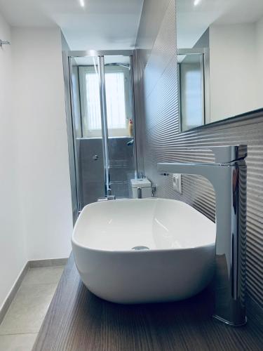 a bathroom with a large white tub and a sink at Casa RoSa in Acitrezza