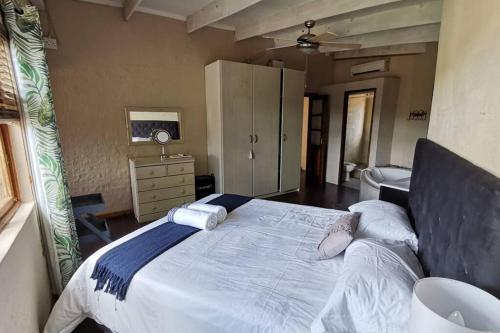 a bedroom with a large bed with white sheets and pillows at Luxury Villa Nelspruit in Nelspruit