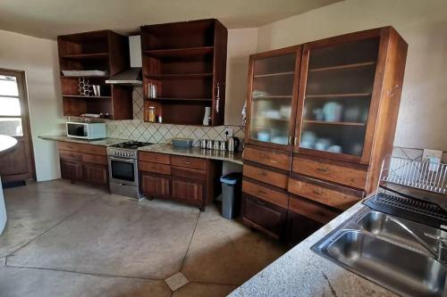 a kitchen with wooden cabinets and a stove top oven at Luxury Villa Nelspruit in Nelspruit
